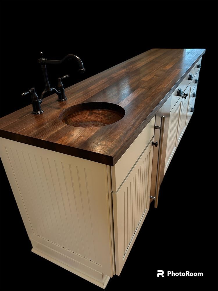 A kitchen counter with a wooden top and a sink.