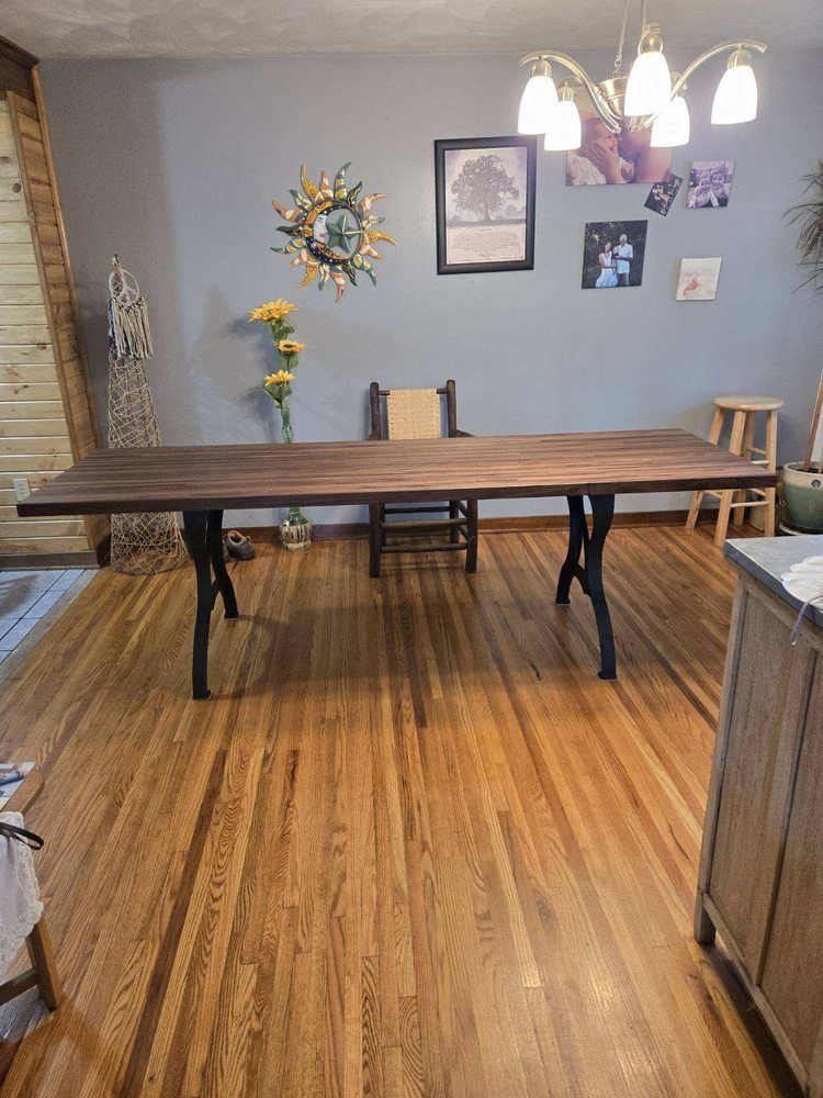 A wooden table is sitting on a wooden floor in a dining room.