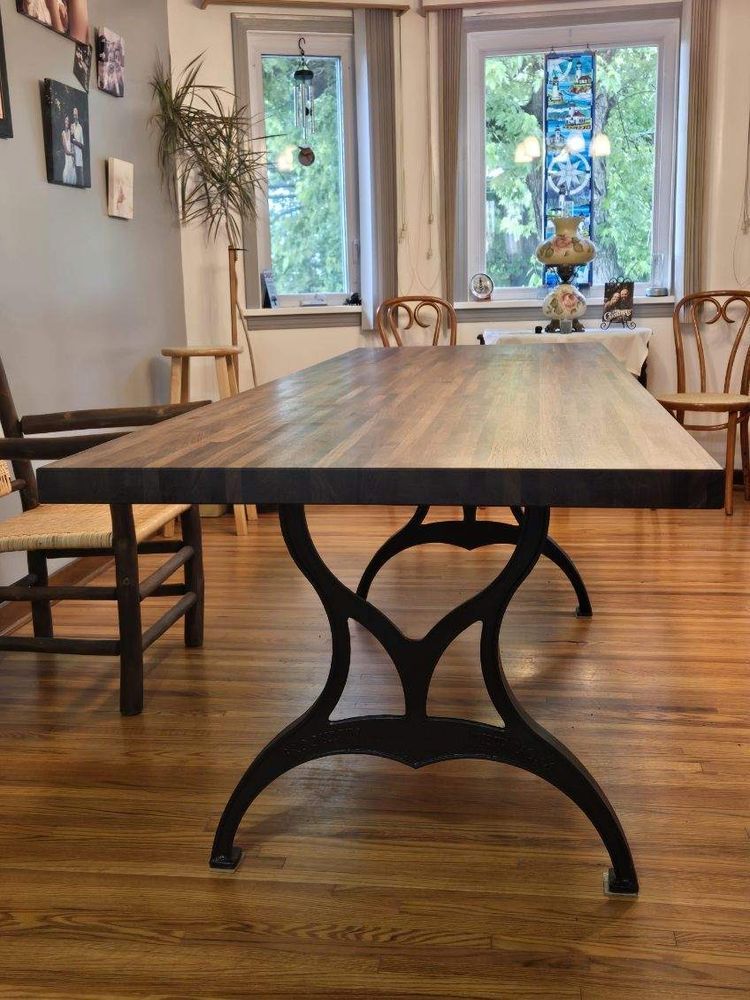 A wooden table with a metal base in a room