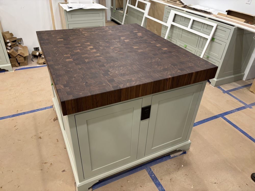 A kitchen island with a wooden counter top in a room.