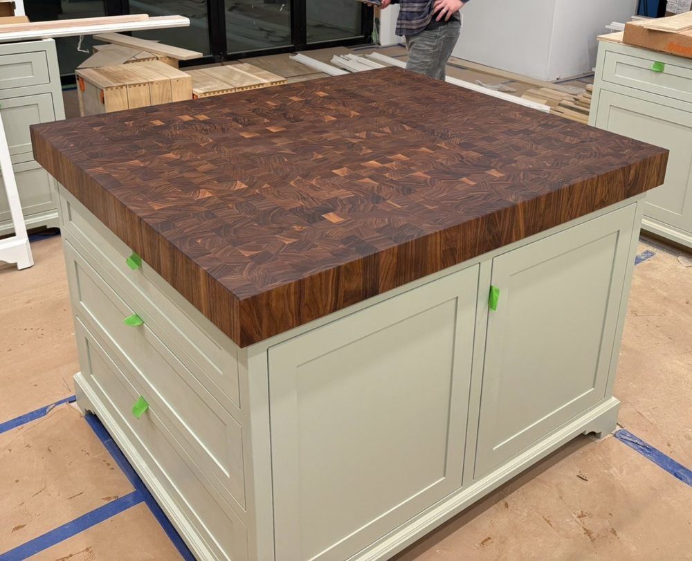 A kitchen island with a cutting board on top of it.