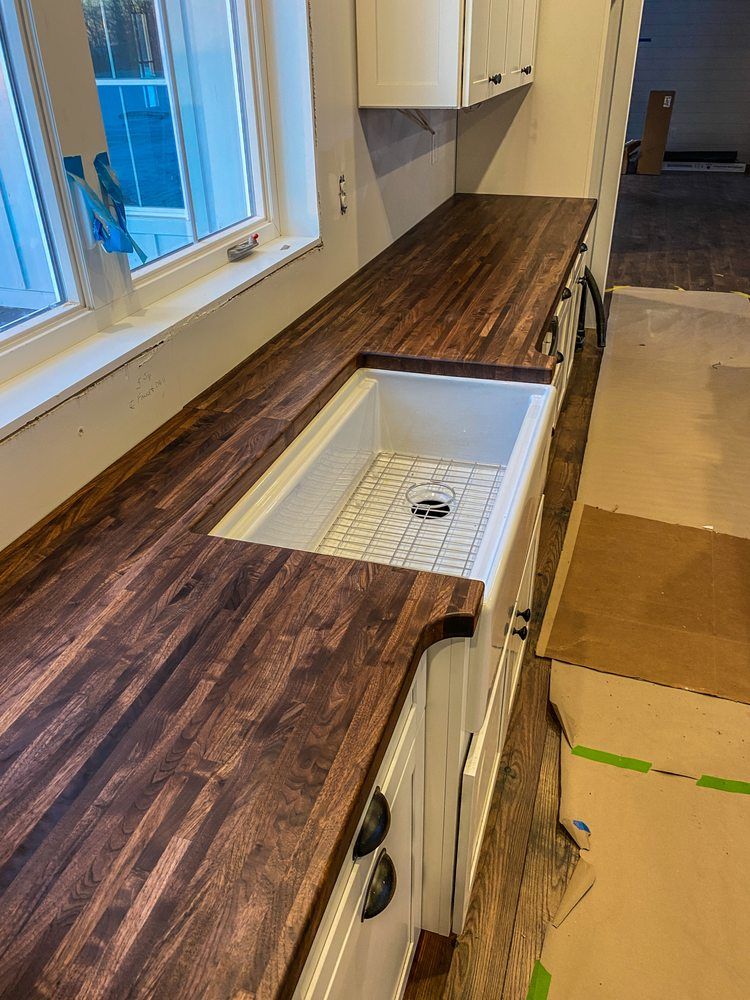 A kitchen with a wooden counter top and a white sink.