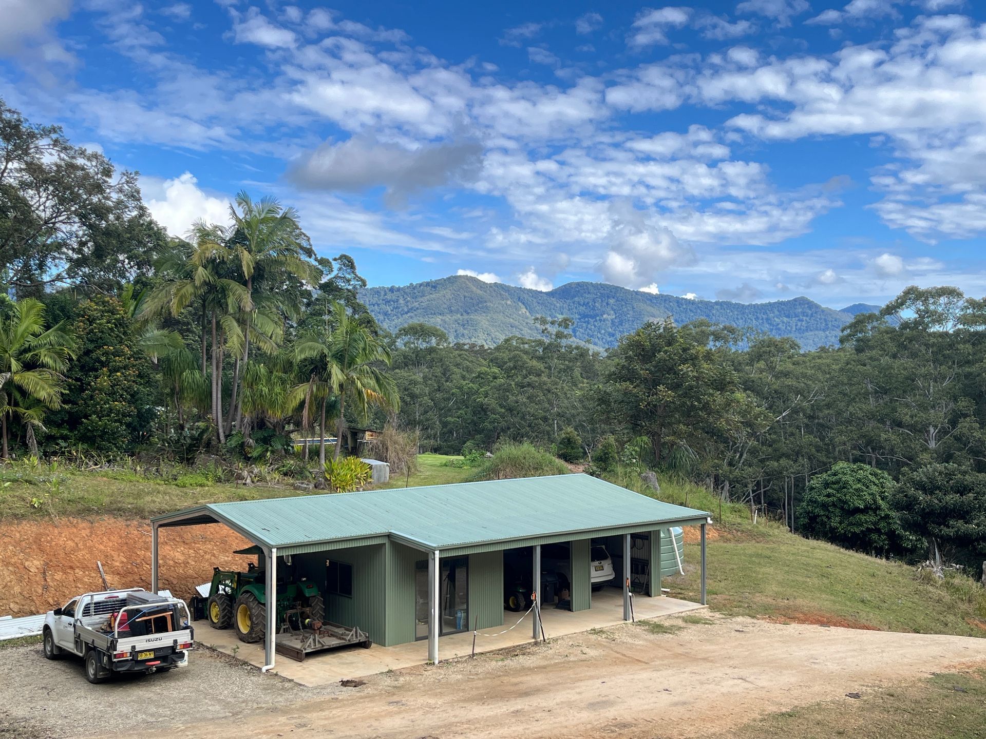 A Ute is Parked in Front of a Shed With Mountains in the Background — Urbon Sheds in Uki, NSW