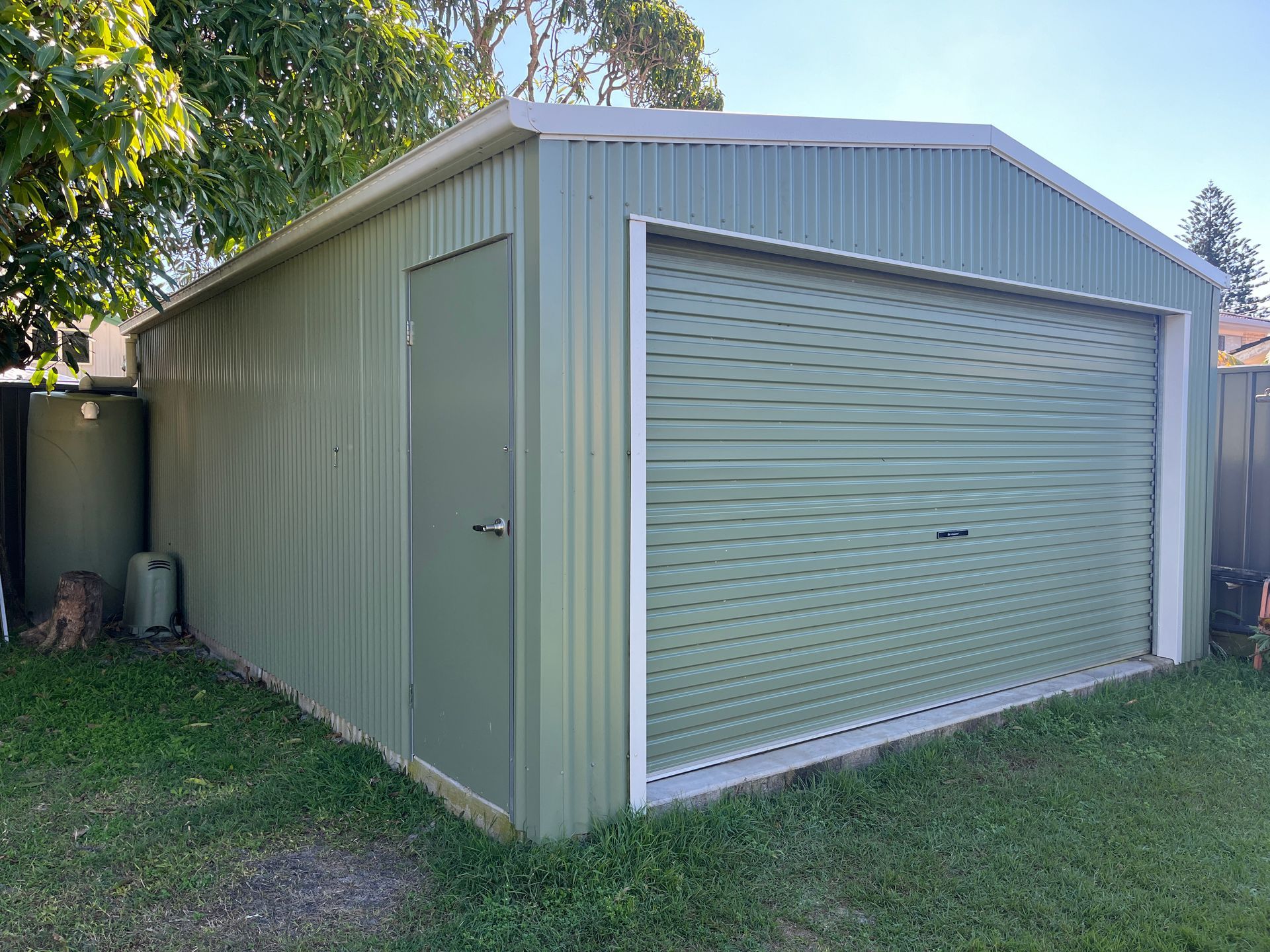 A Shed Is Sitting In The Middle Of A Lush Green Field — Urbon Sheds in Casino, NSW