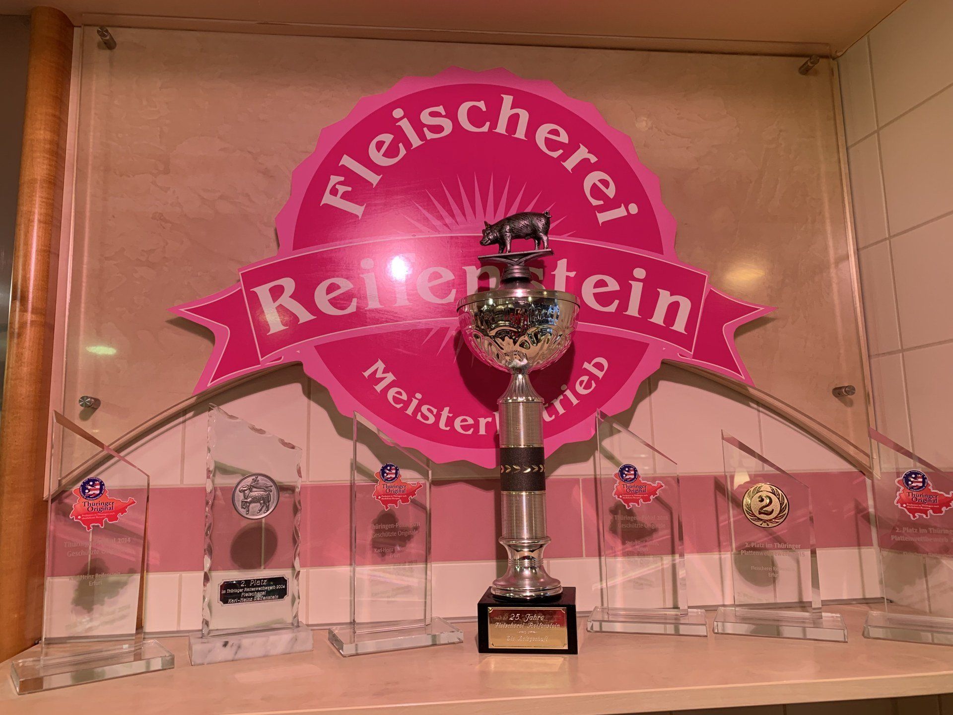 Eine Trophäe vor einem Schild mit der Aufschrift „Fleischerei“