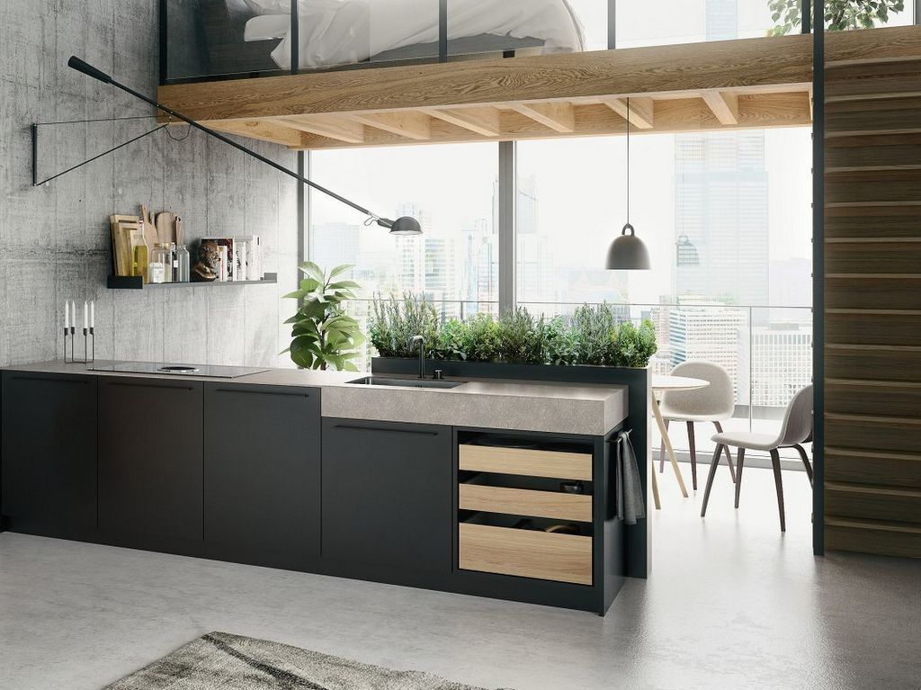 Cuisine moderne avec armoires noires, comptoir en béton, éléments en bois et mezzanine.