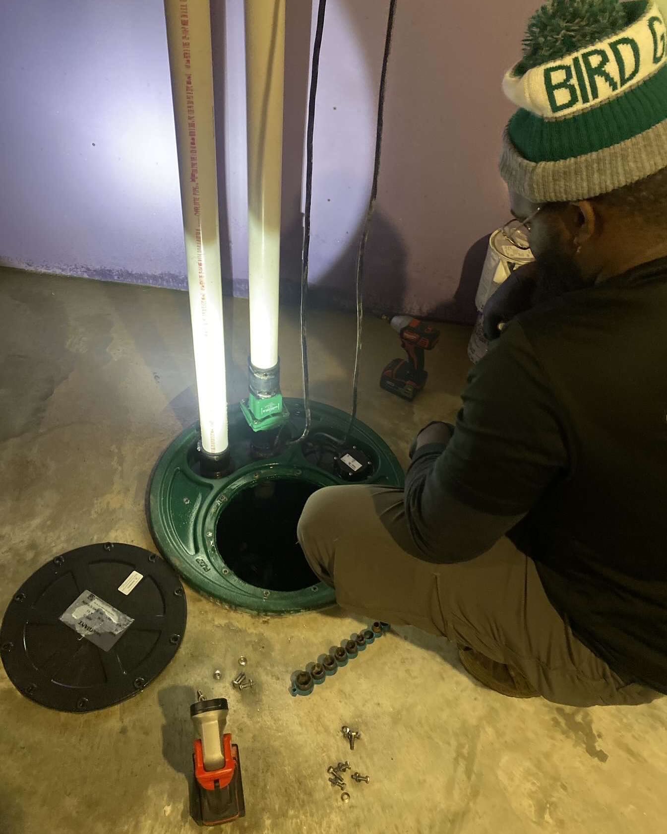 A plumber is fixing a sink faucet in a kitchen