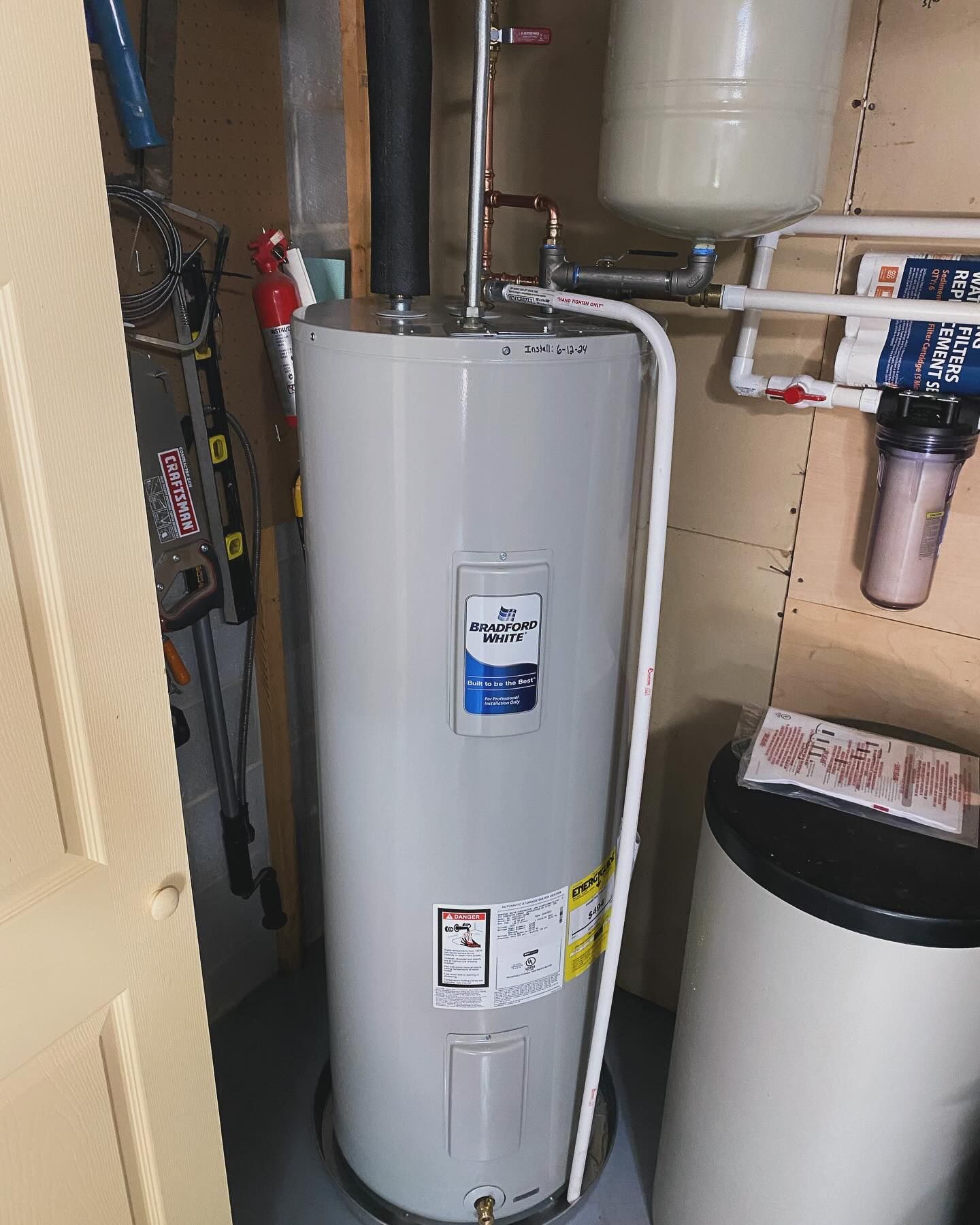 A person is fixing a sink pipe with a wrench.