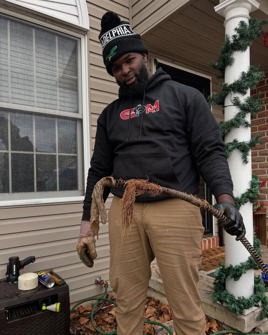 A man wearing a black hoodie with the word alpha on it