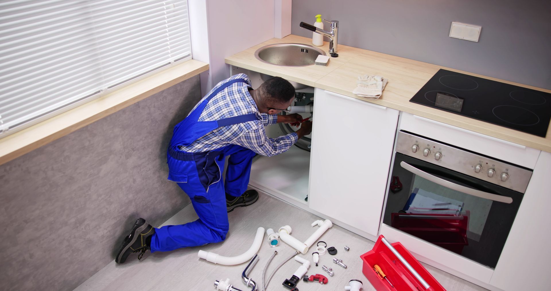 A man is cleaning a toilet with a plunger in a bathroom.