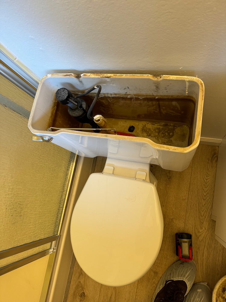 A toilet with water coming out of it in a bathroom.