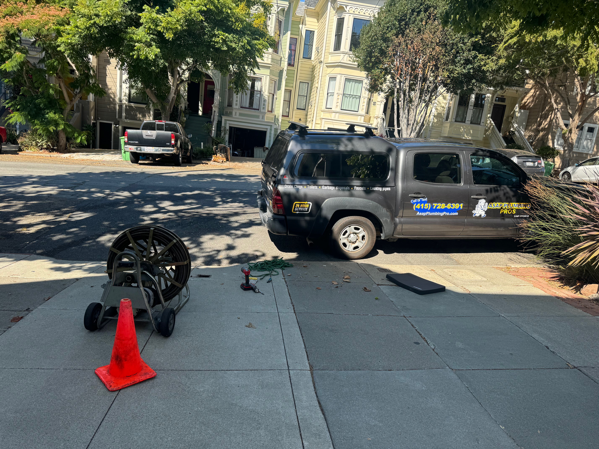 A van is parked on the side of the road next to a cone.