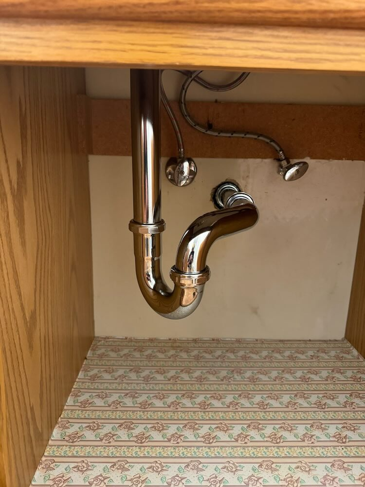 A bathroom sink with a plumbing pipe underneath it.