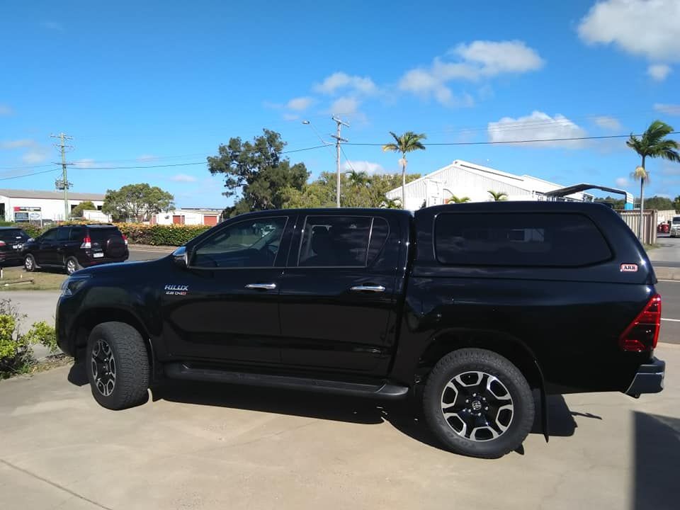 Black Pickup Truck With Camper Shell, Parked Outside on a Sunny Day — Stay on Track 4X4 Accessories in Gladstone Central, QLD