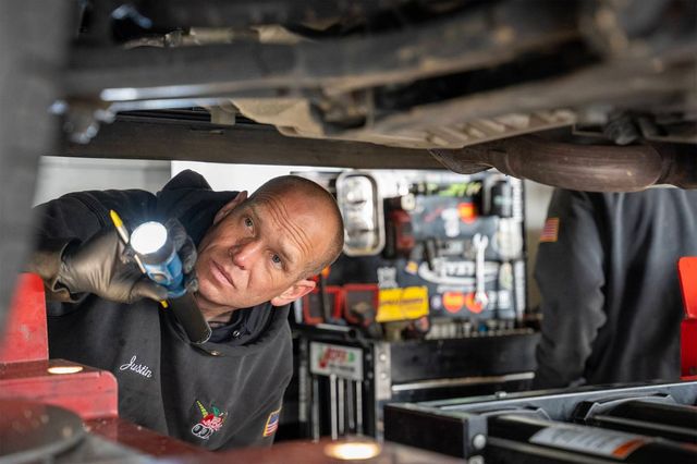 Mechanic looking under car | Big Apple Automotive