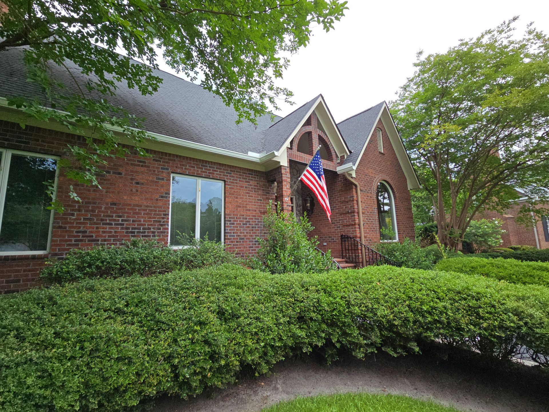 A large brick house with a flag in front of it.