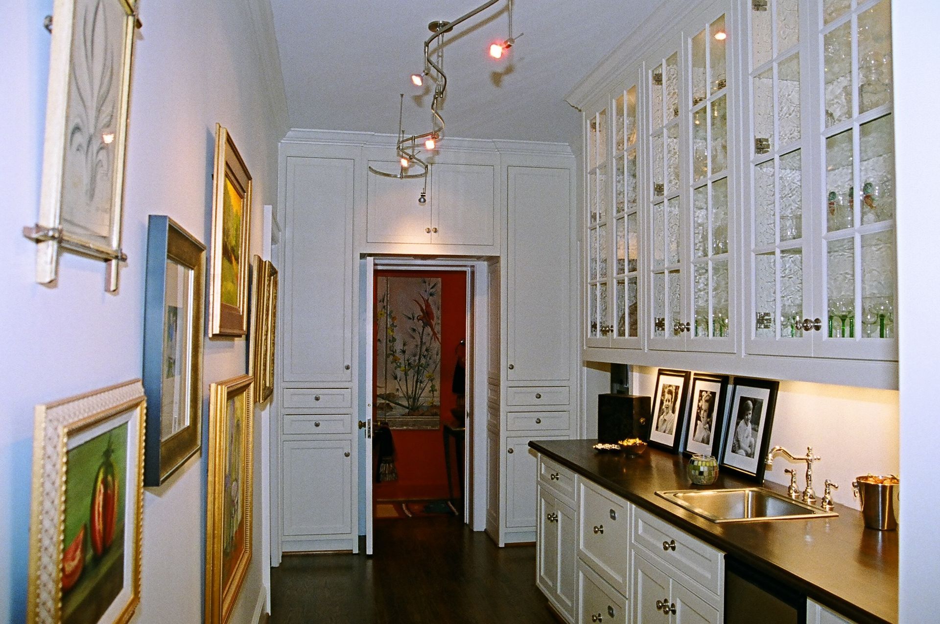 A kitchen with white cabinets and black counter tops