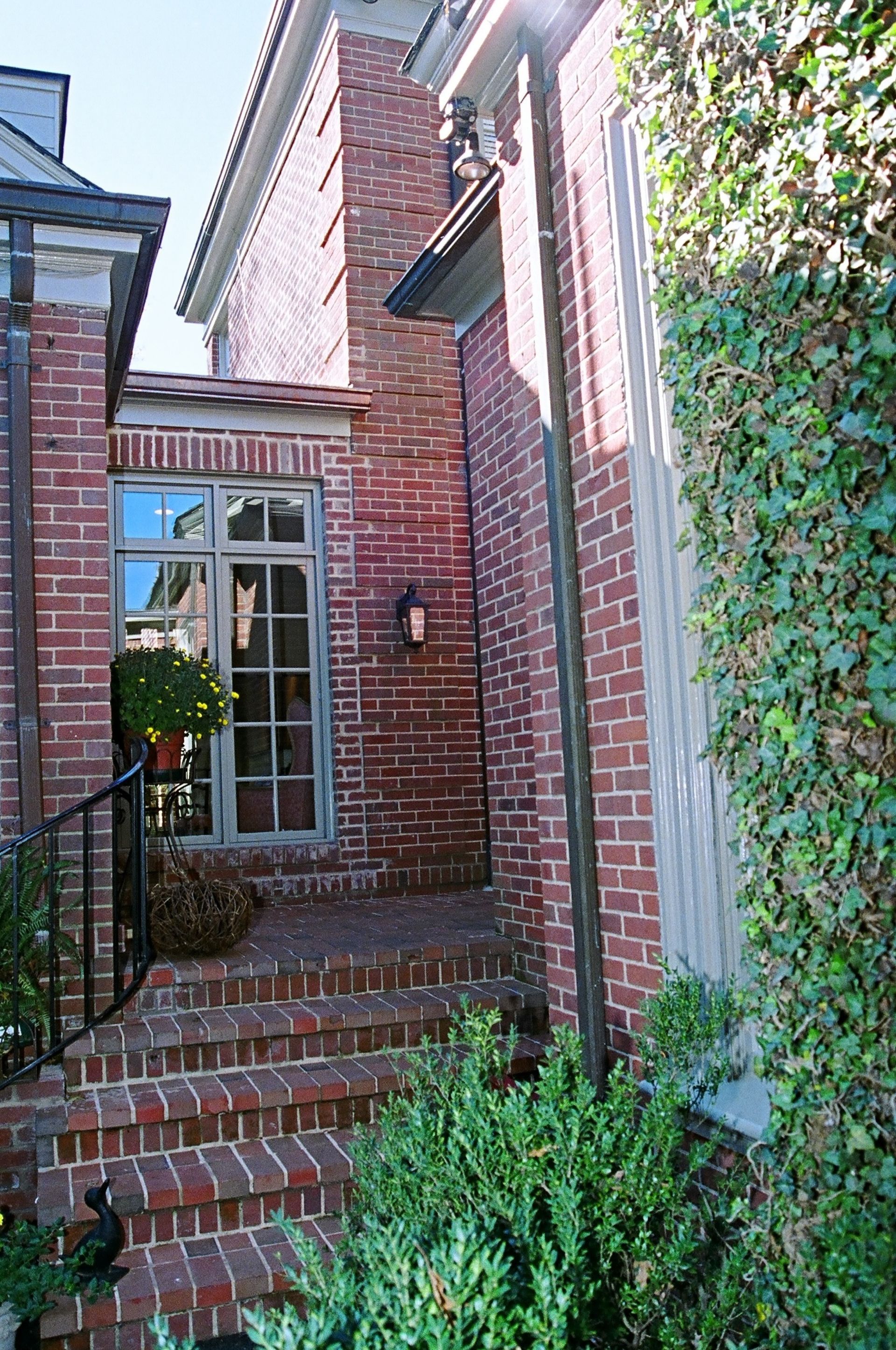 A brick house with stairs leading up to the front door.