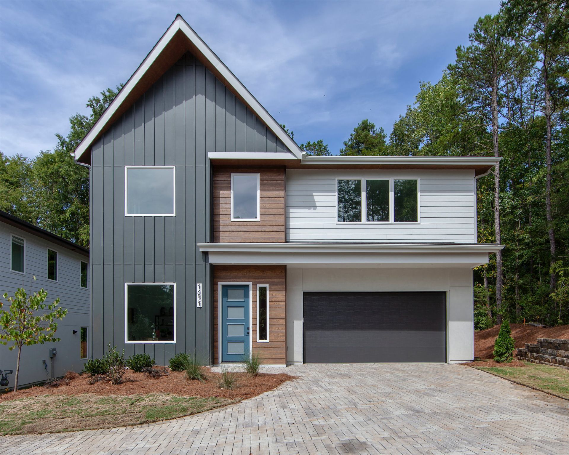 a modern house with a large garage and a blue door