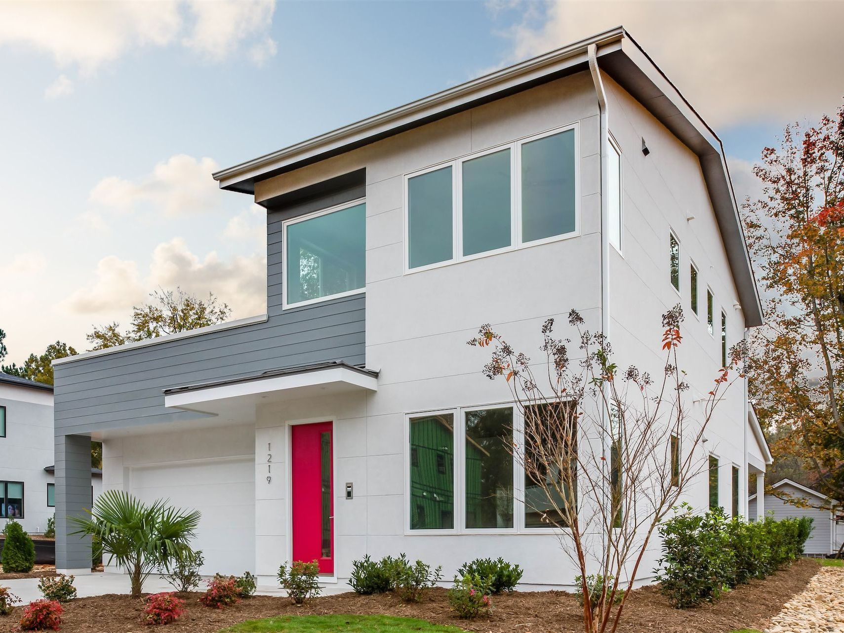 a white house with a red door and a lot of windows