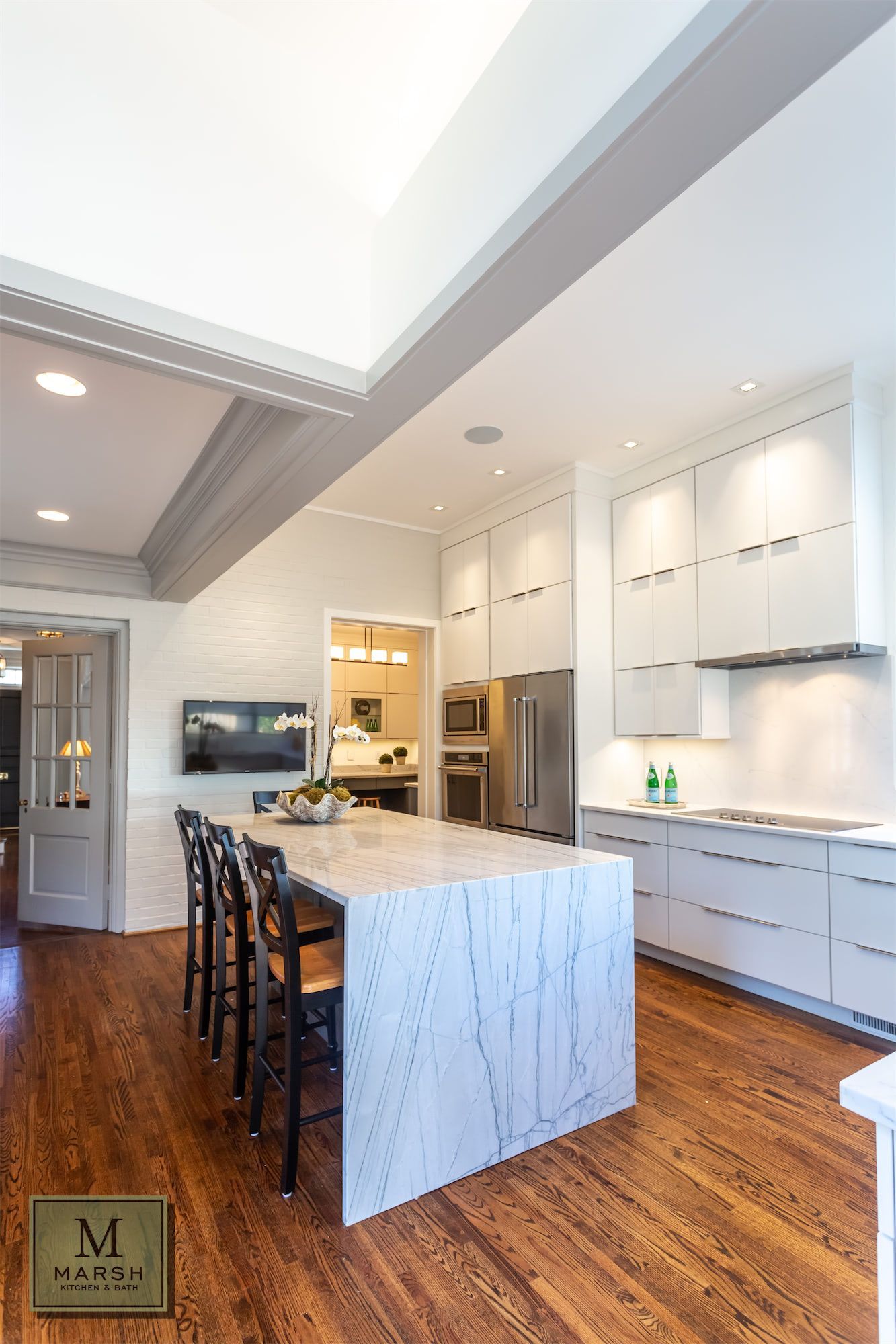 a kitchen with white cabinets and a large island in the middle .