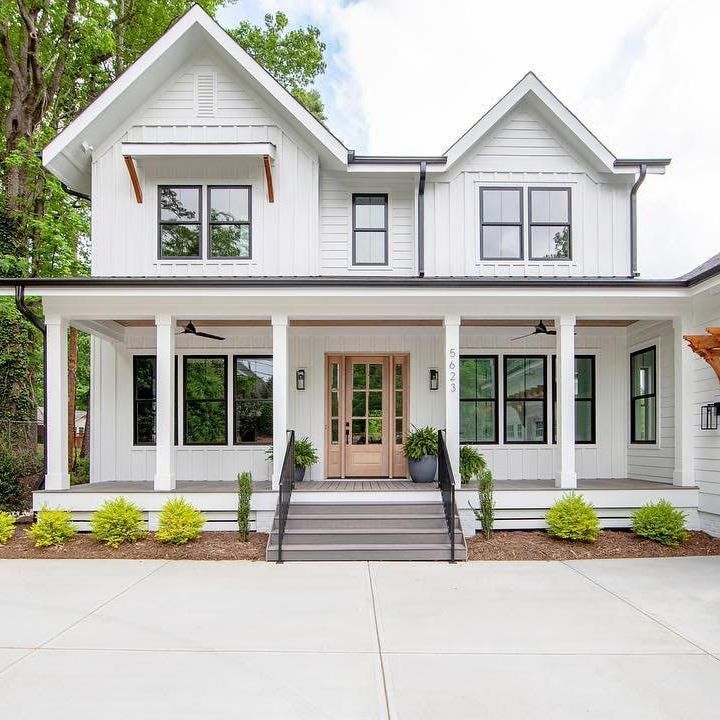 a large white house with a large porch and stairs leading up to it .
