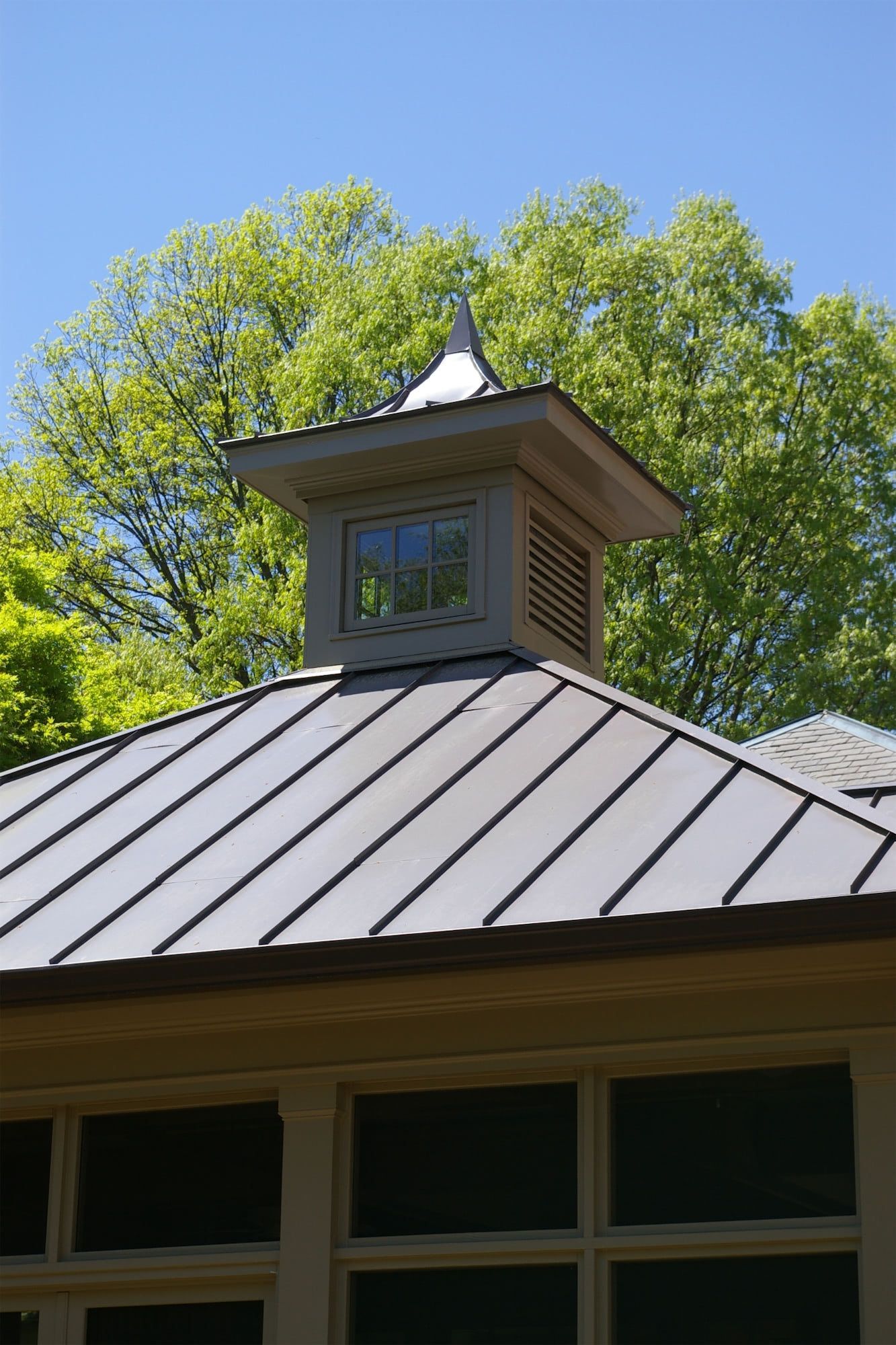 A roof with a chimney on top of it and trees in the background