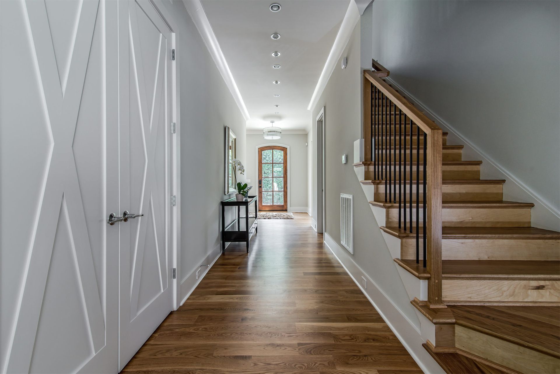 a hallway with wooden floors and stairs in a house .
