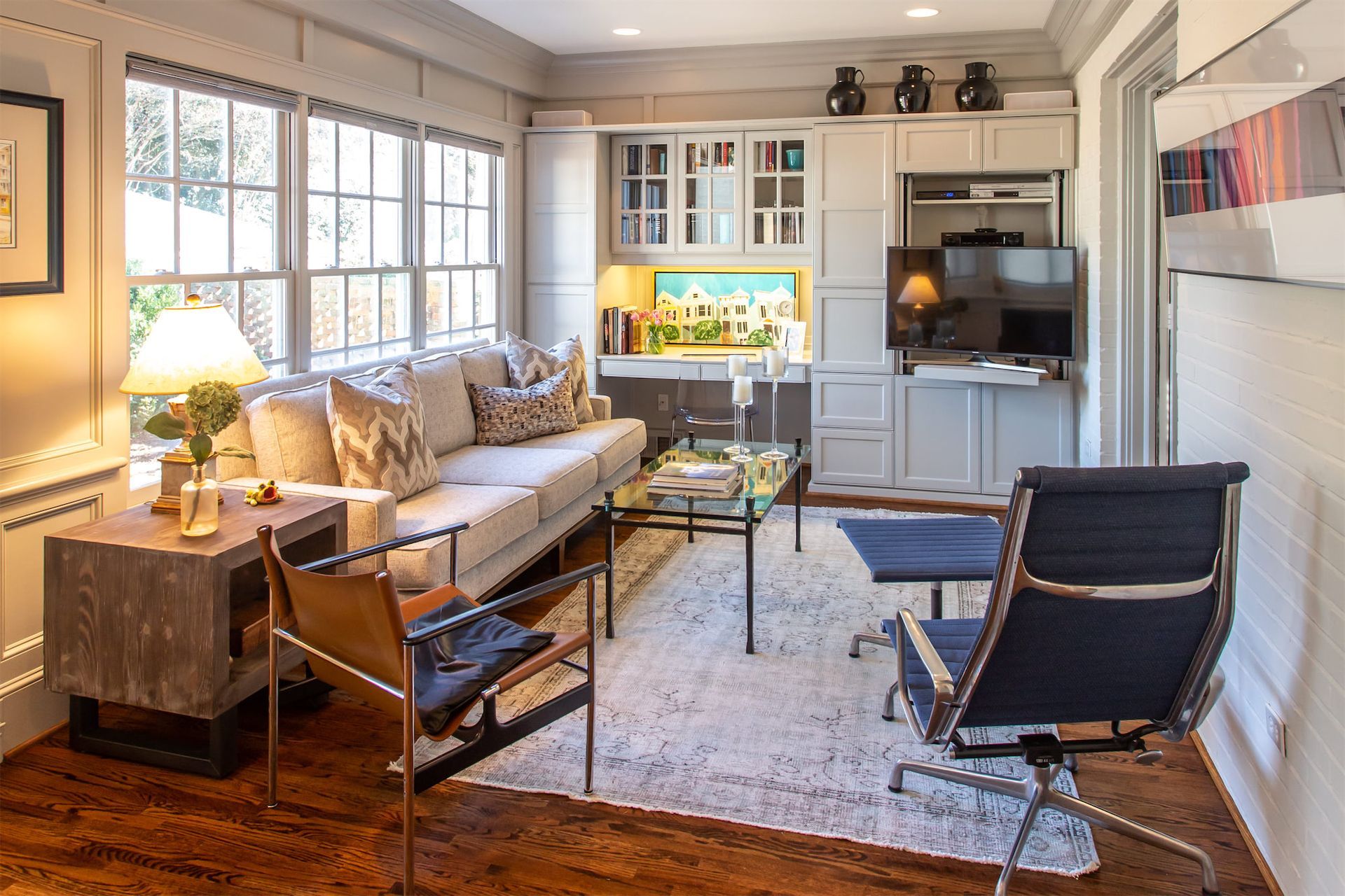 A living room with a couch , chairs , coffee table and television.