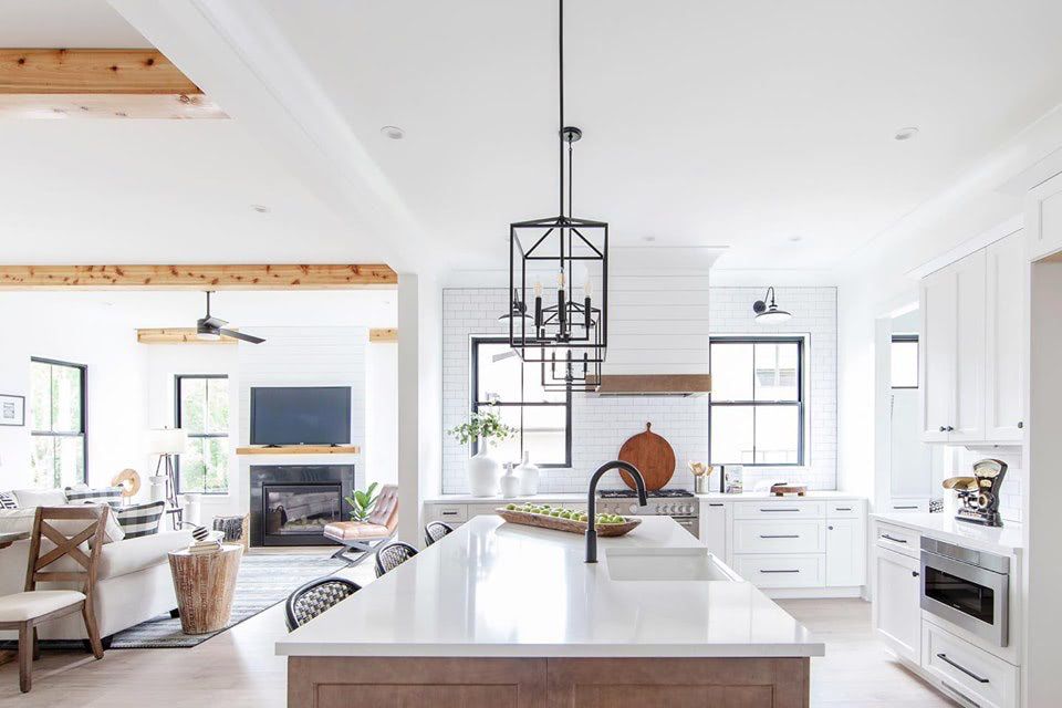 a kitchen with white cabinets and a large island in the middle .