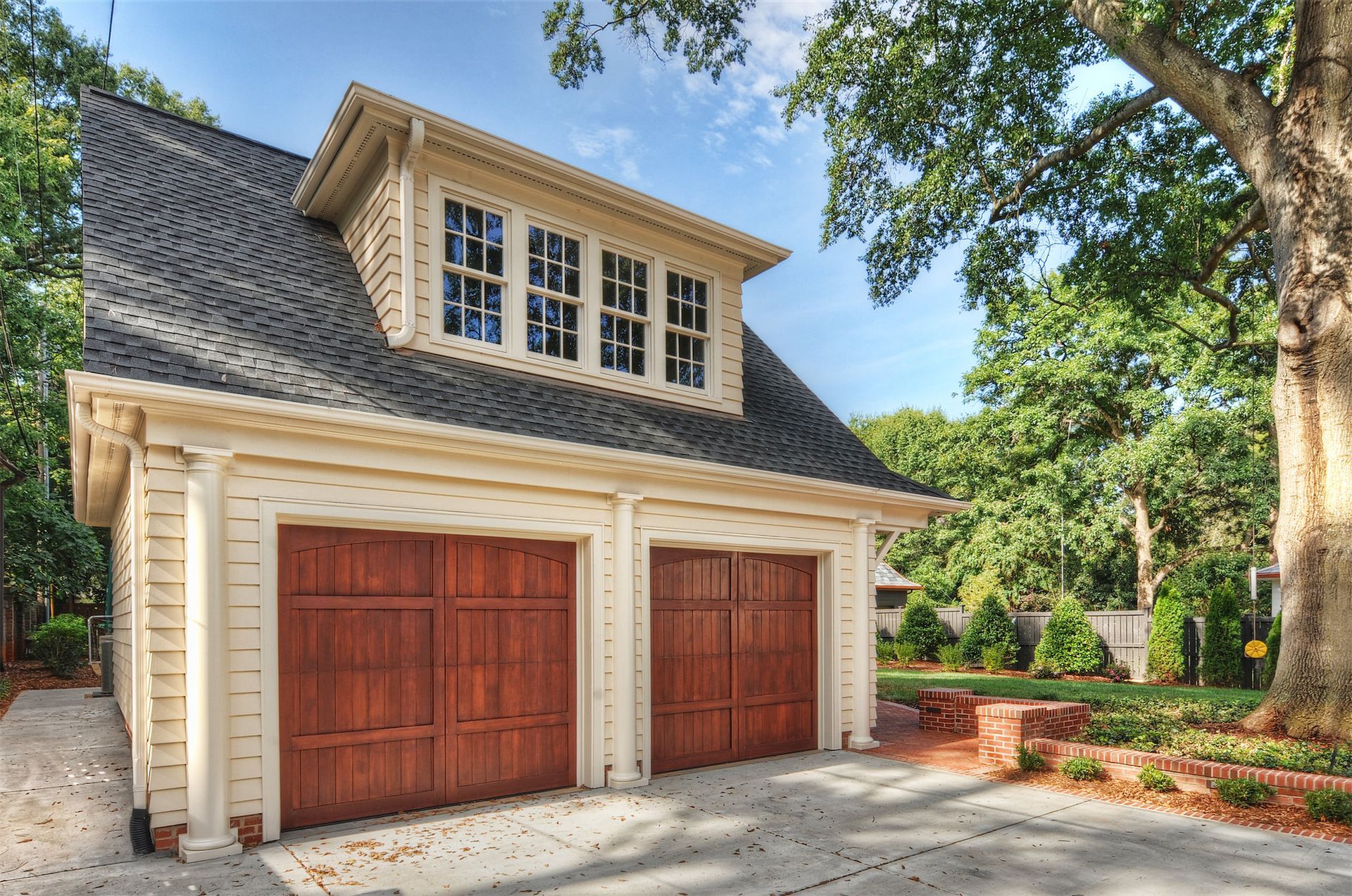A garage with two wooden doors and a black roof