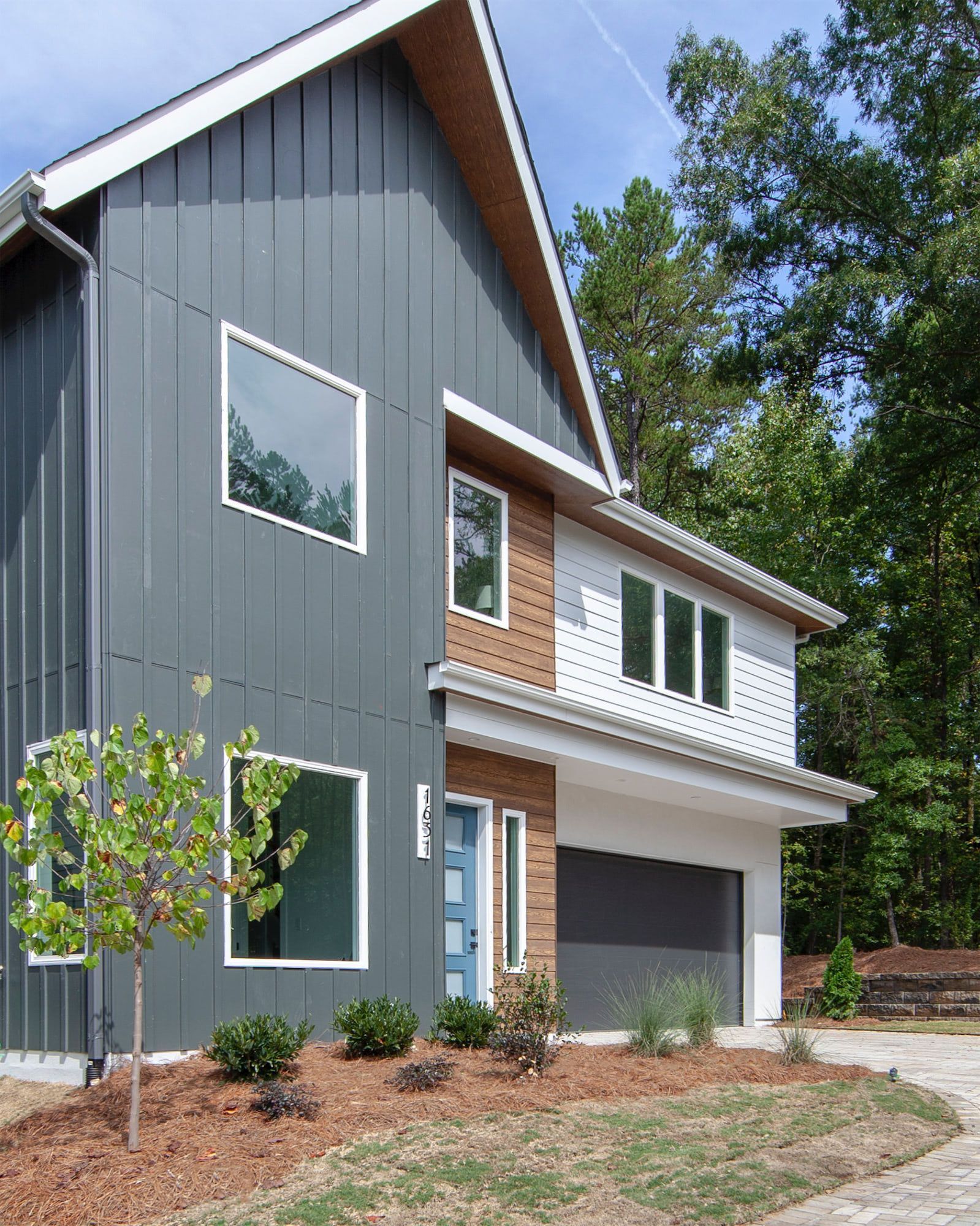A gray and white house with a blue garage door