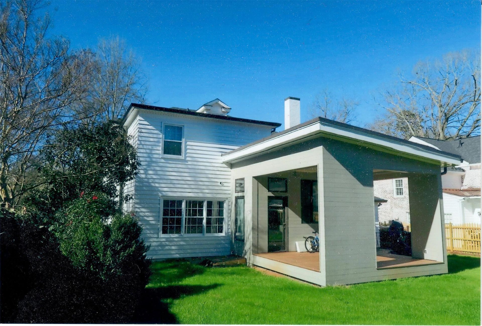 A white house with a covered porch in the backyard