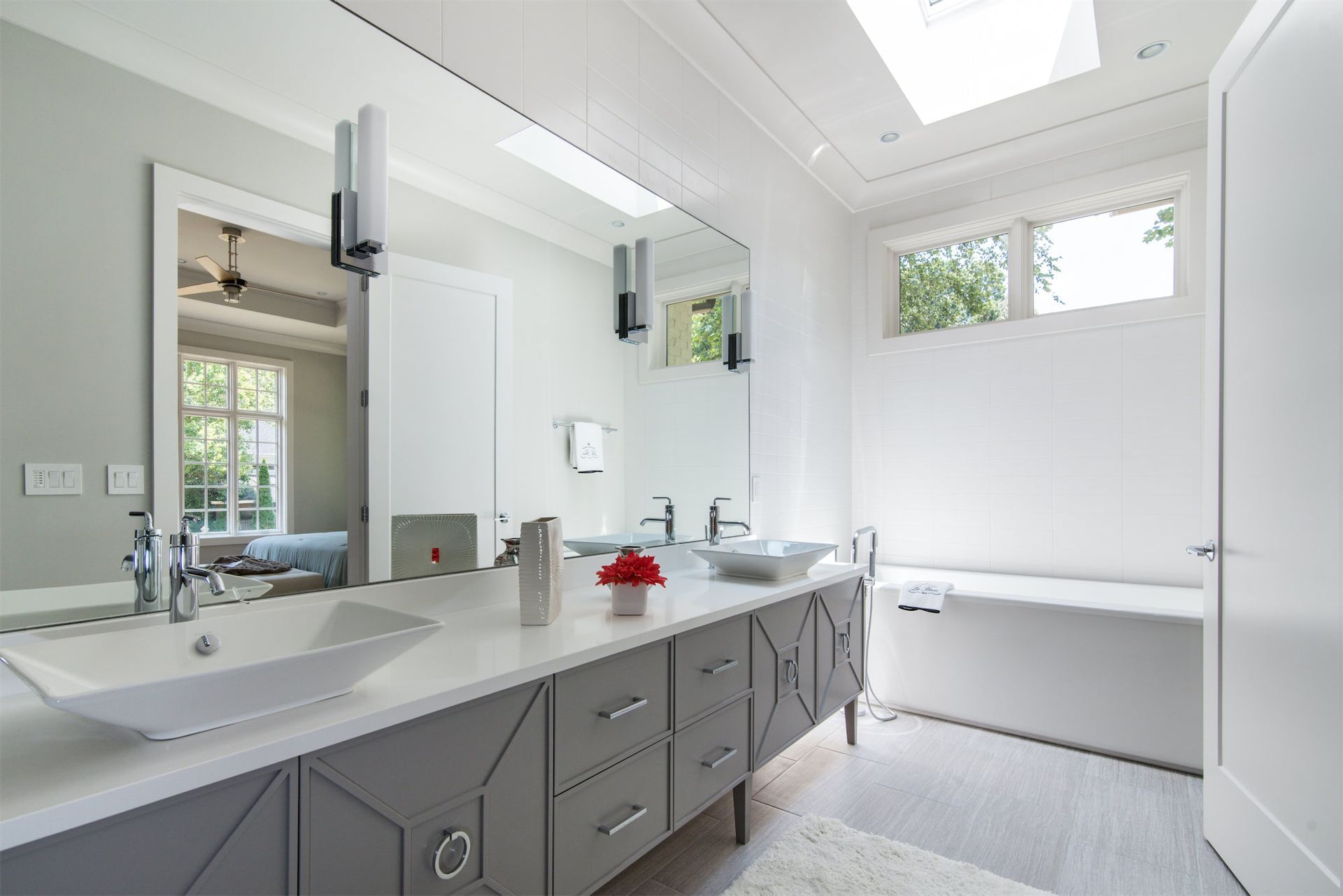 a bathroom with two sinks , a tub and a large mirror .