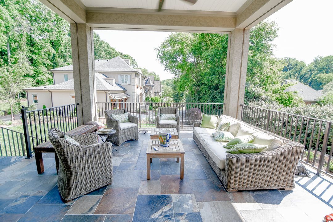 a patio with a couch , chairs , and a table .