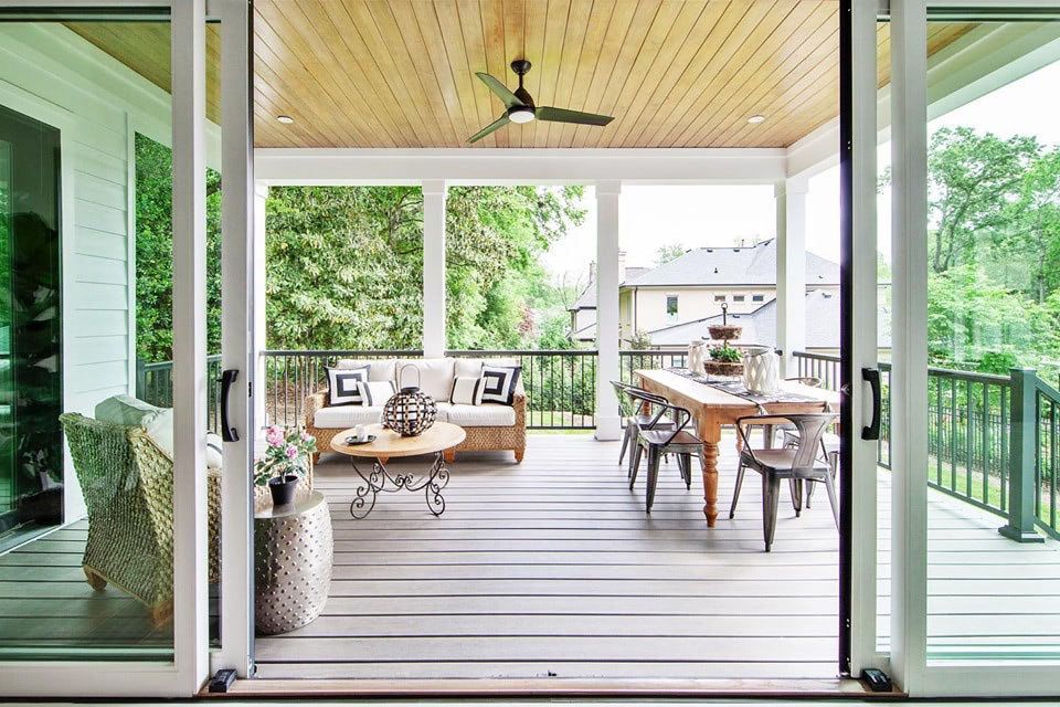 a porch with a table and chairs and a ceiling fan