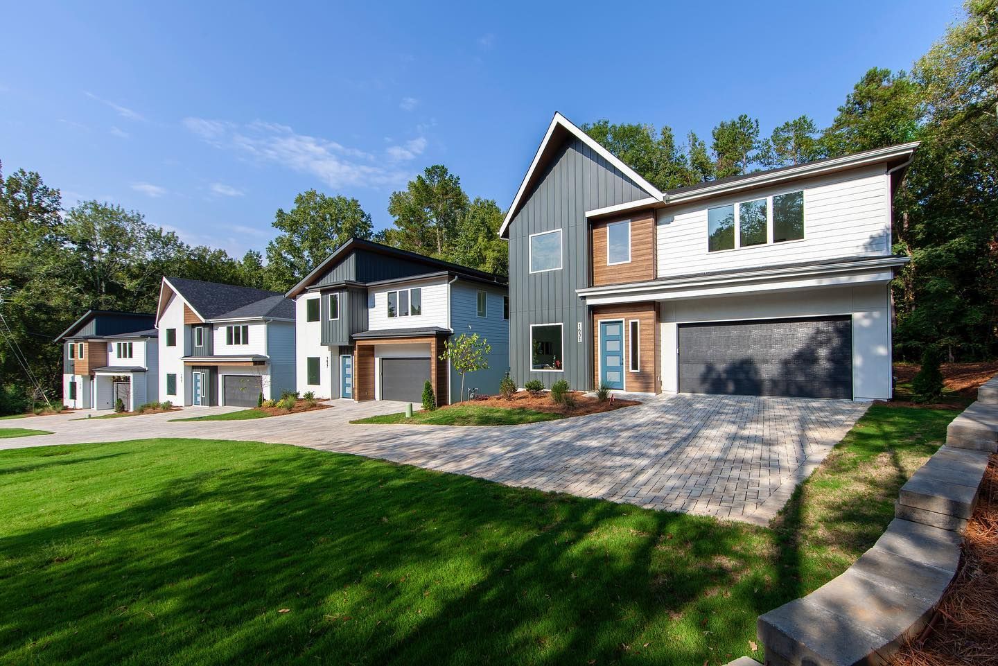 A row of houses sitting next to each other on a lush green lawn.