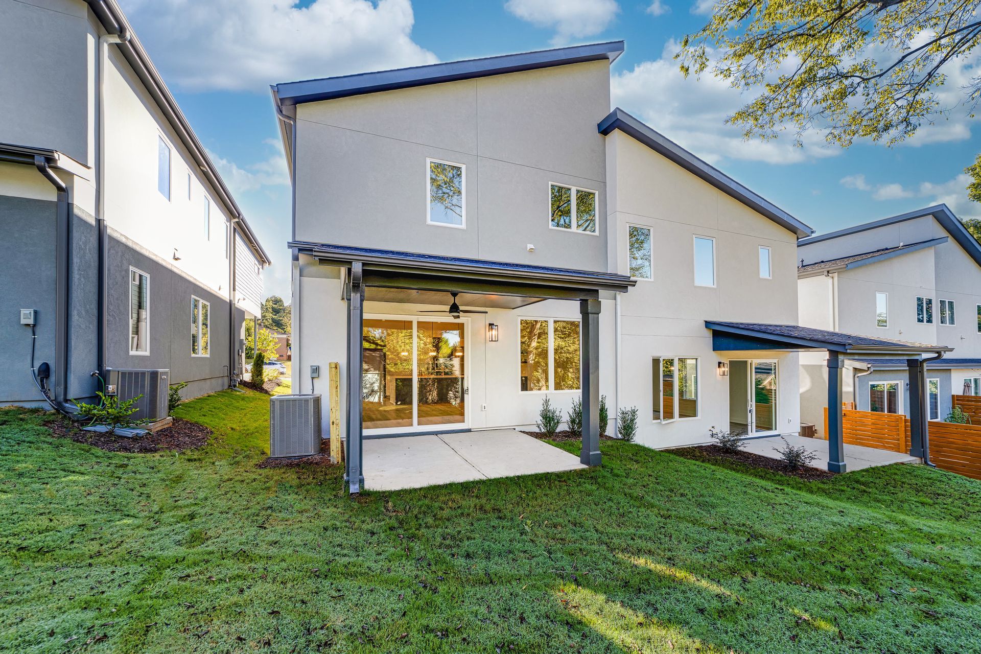 The back of a house with a large lawn in front of it.