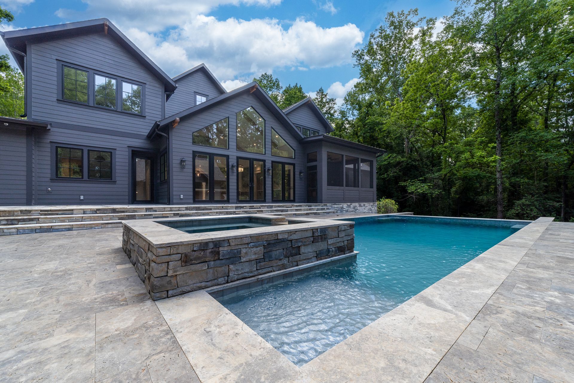 A large house with a large swimming pool in front of it.