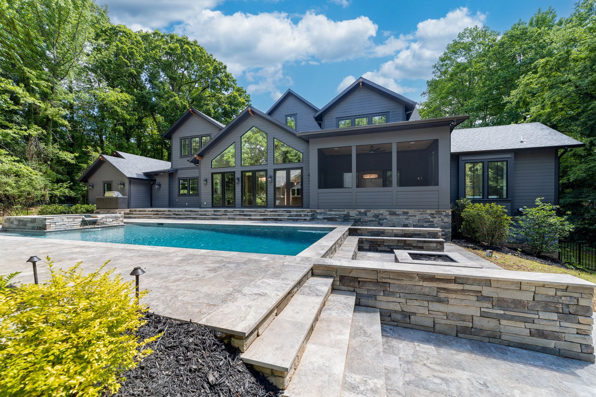 A large house with a large swimming pool in front of it.