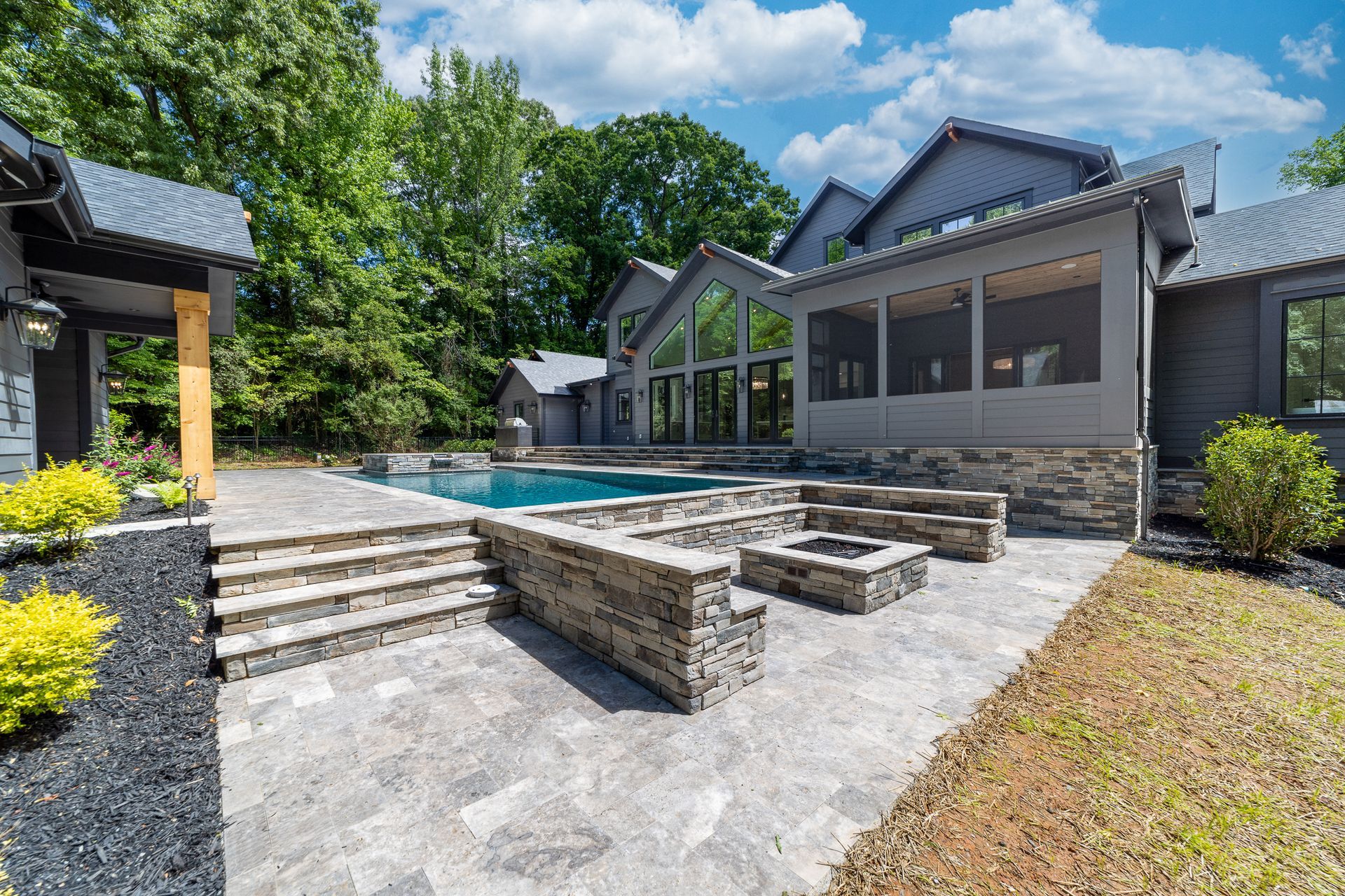 A large house with a swimming pool and a fire pit in the backyard.