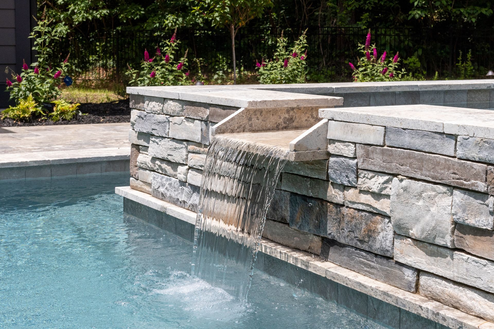 There is a waterfall in the middle of the pool.