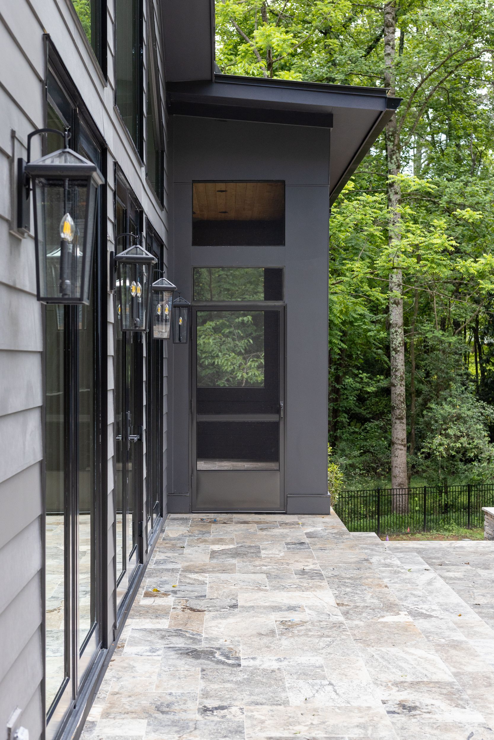 A house with a lot of windows and a patio in front of it