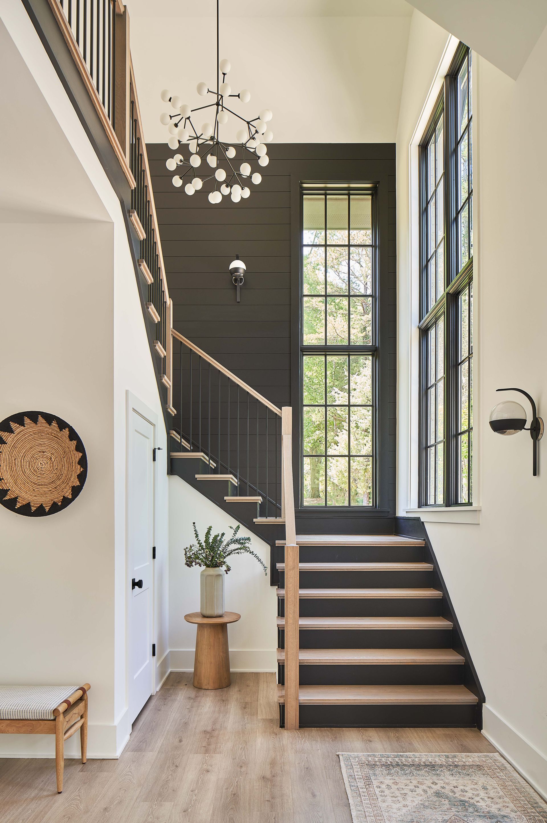 A hallway with a staircase and a large window