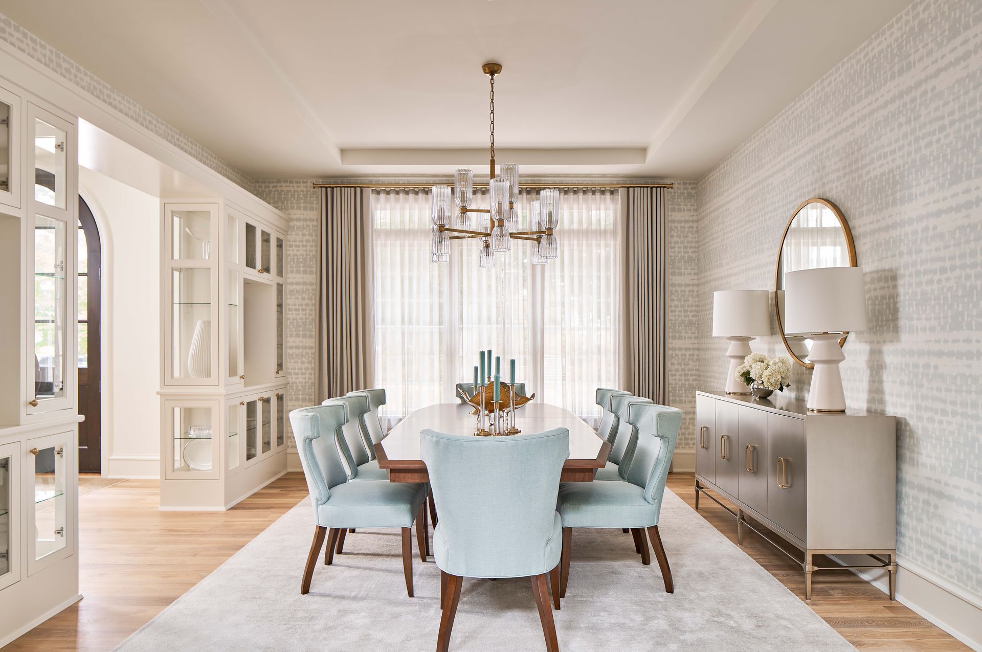 A dining room with a table and chairs and a chandelier.