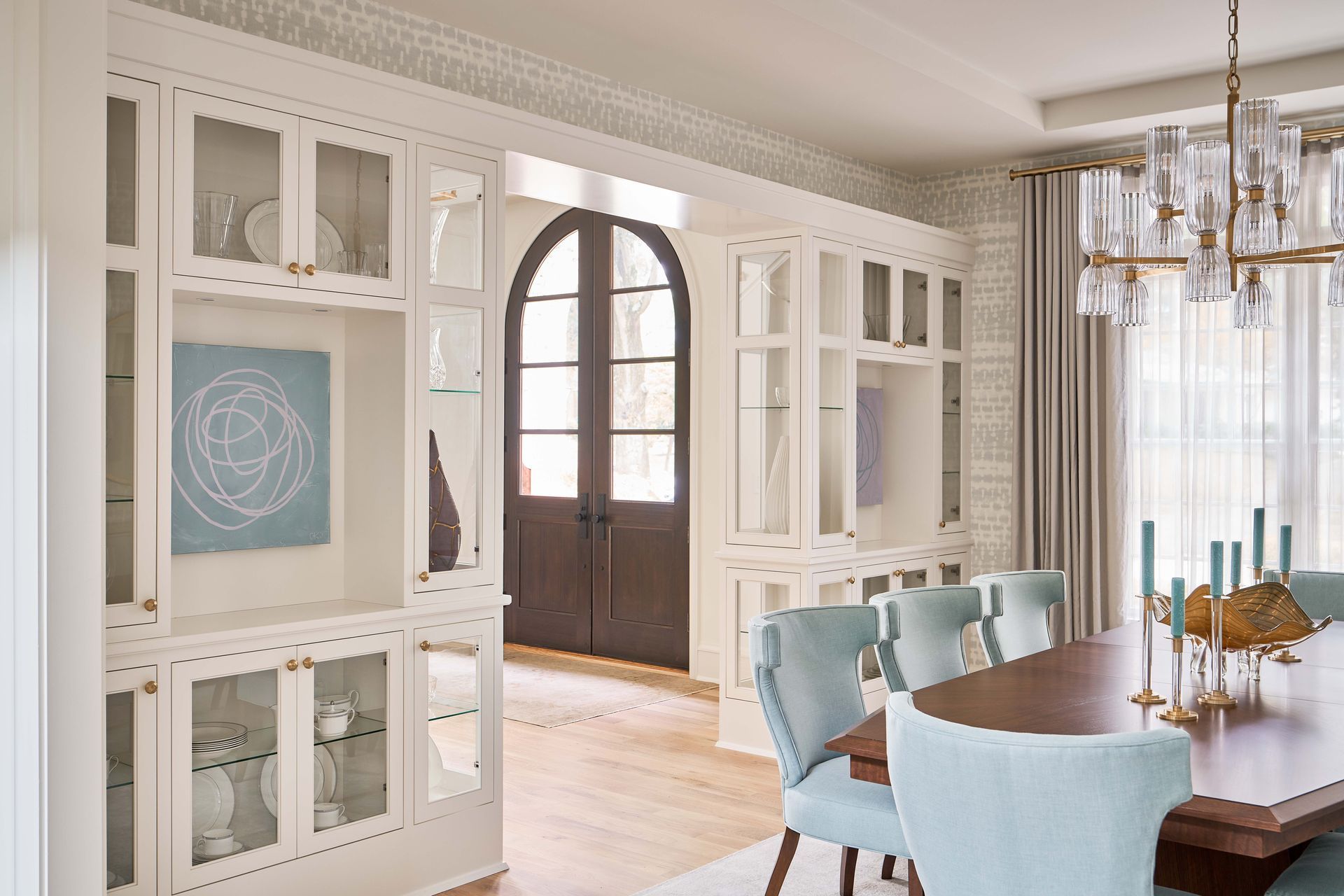 A dining room with a table and chairs and a chandelier.