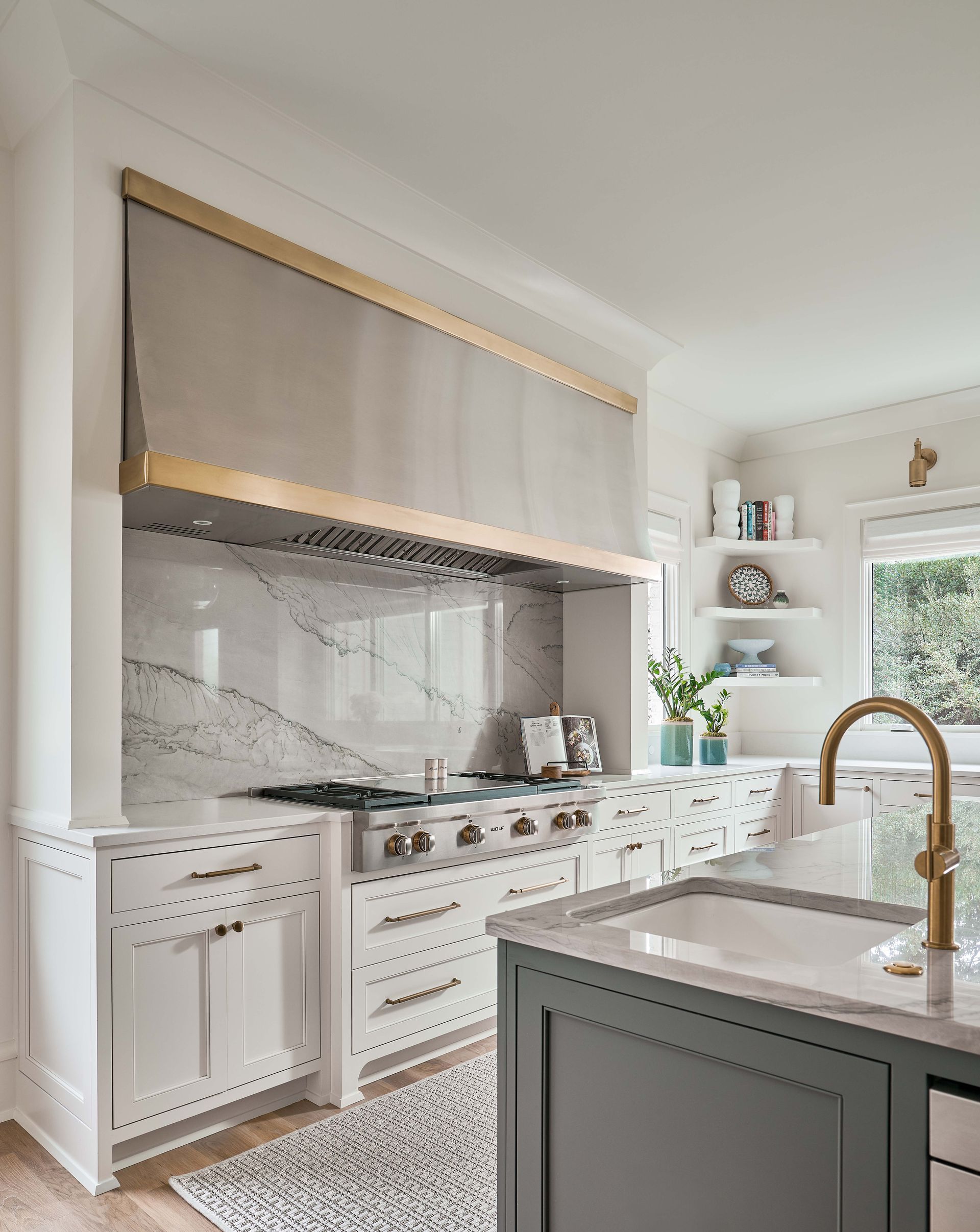 A kitchen with white cabinets , stainless steel appliances , a sink and a stove.