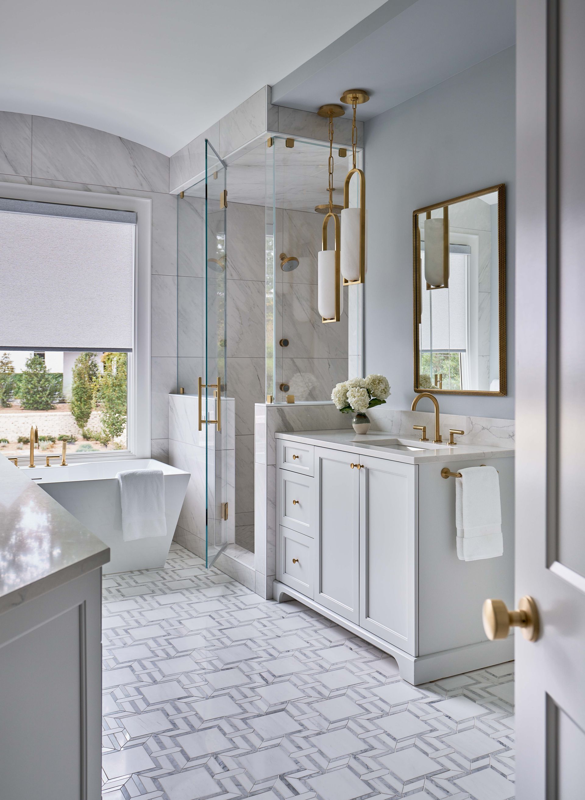 A bathroom with a tub , sink , mirror and walk in shower.