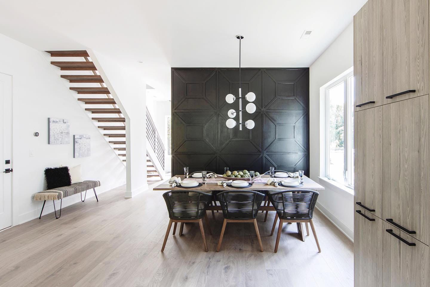 a dining room with a table and chairs and a black wall .