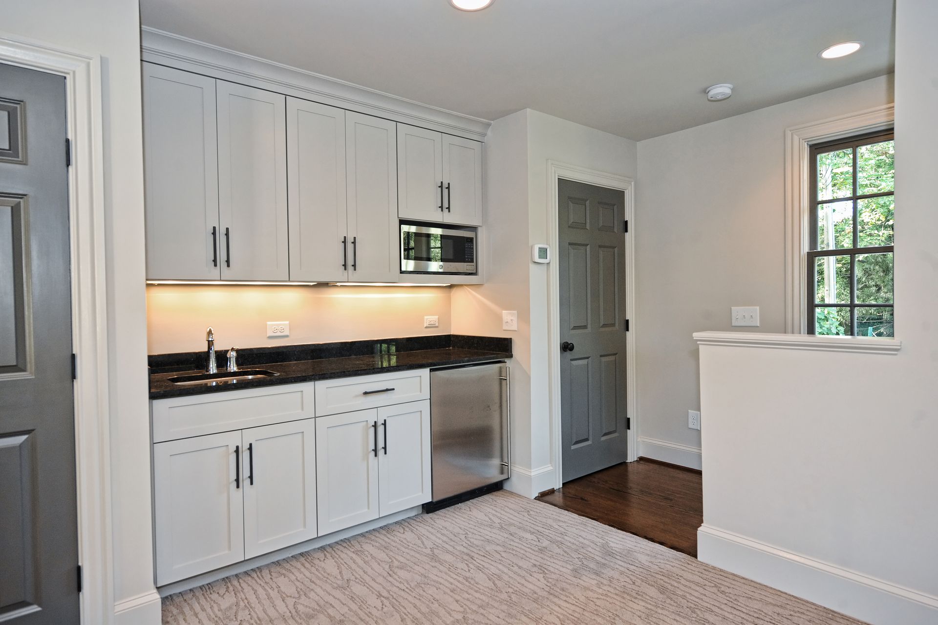A kitchen with white cabinets and stainless steel appliances